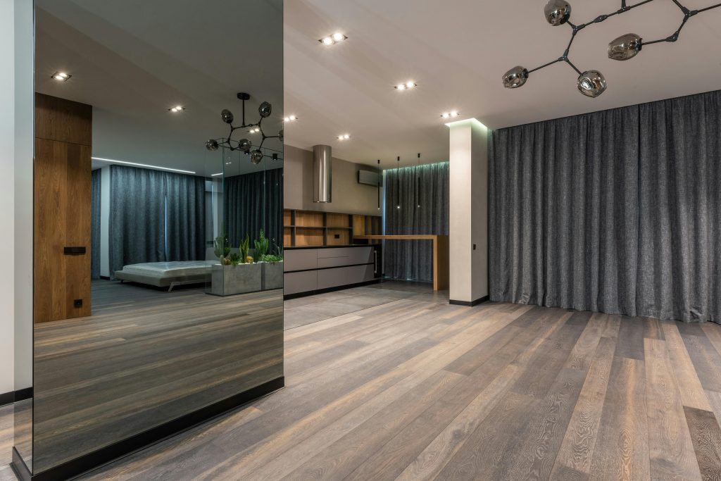 pexels photo 6207950 6207950 Spacious room in apartment with wooden floor decorated with mirrored pillar and green plants